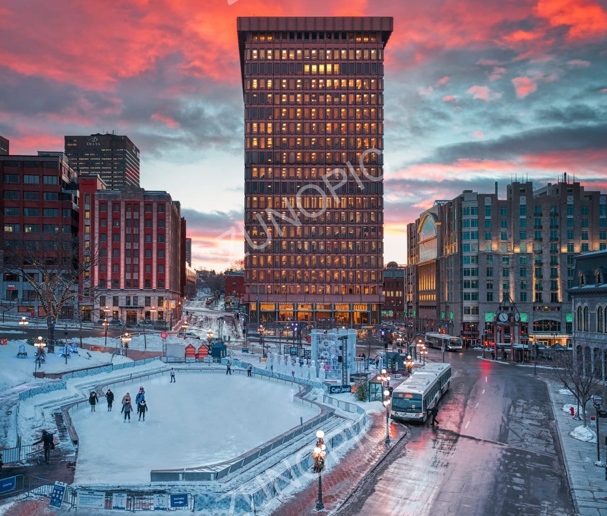City square with an ice rink under a fiery winter sunset
