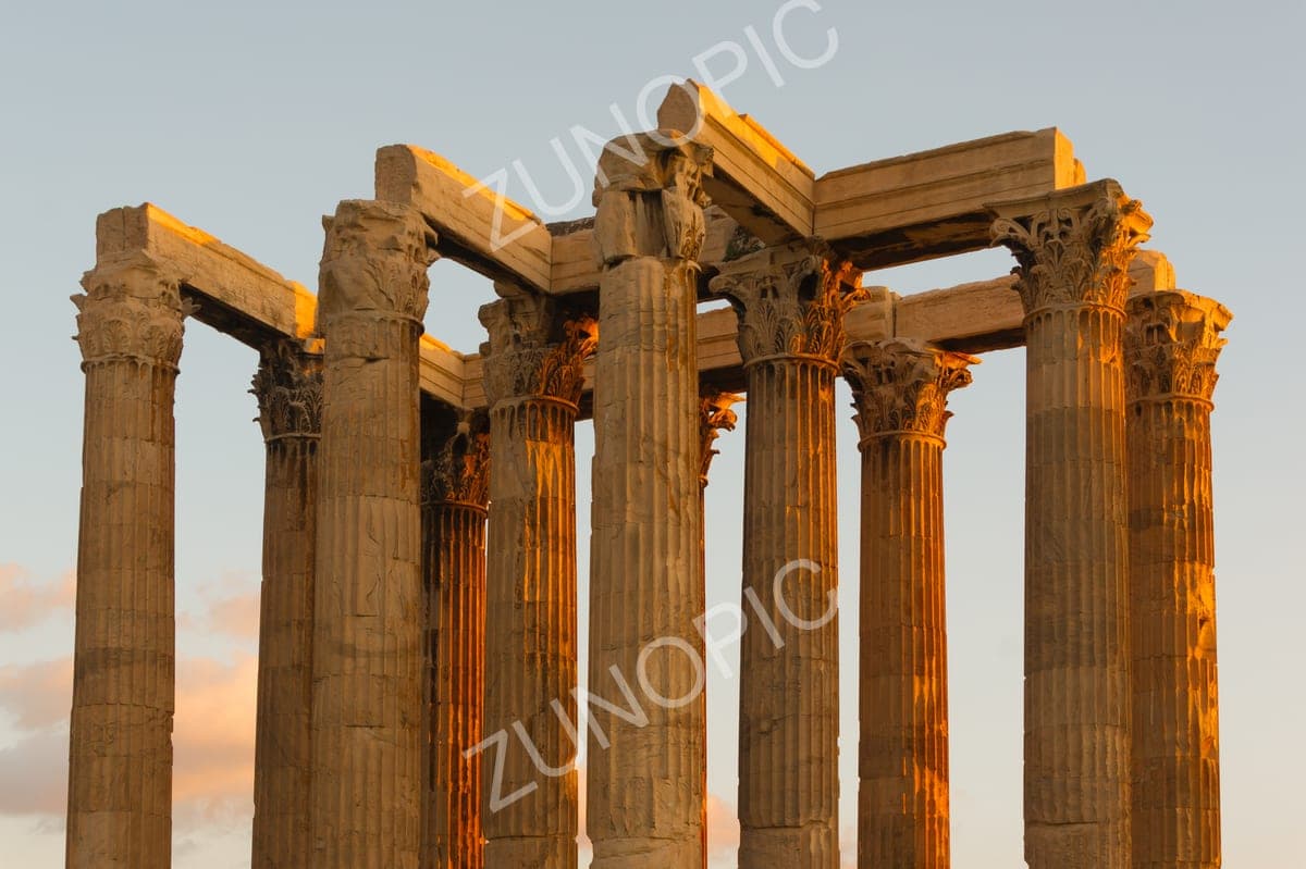 Corinthian columns of an ancient temple glowing at sunset