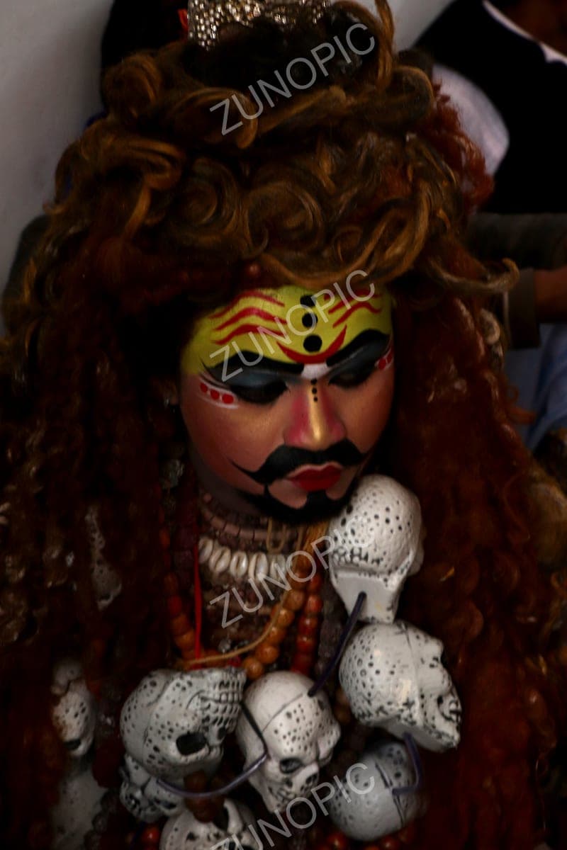 Performer dressed as a fierce deity with a skull garland