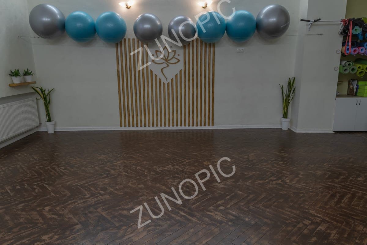 Bright yoga studio with exercise balls and wooden floor