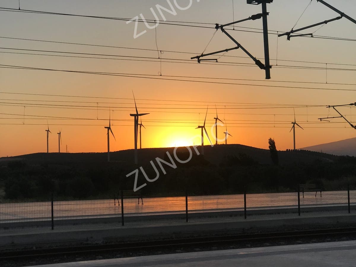 Wind turbines silhouetted against the sunset