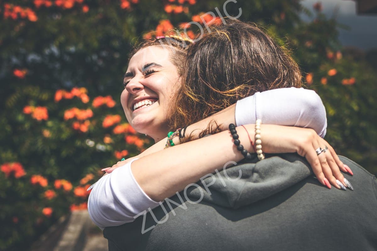 Happy couple hugging among flowers