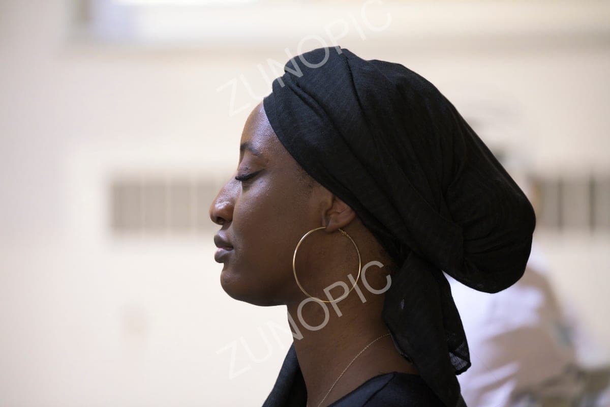 Profile portrait of a woman in a black headwrap